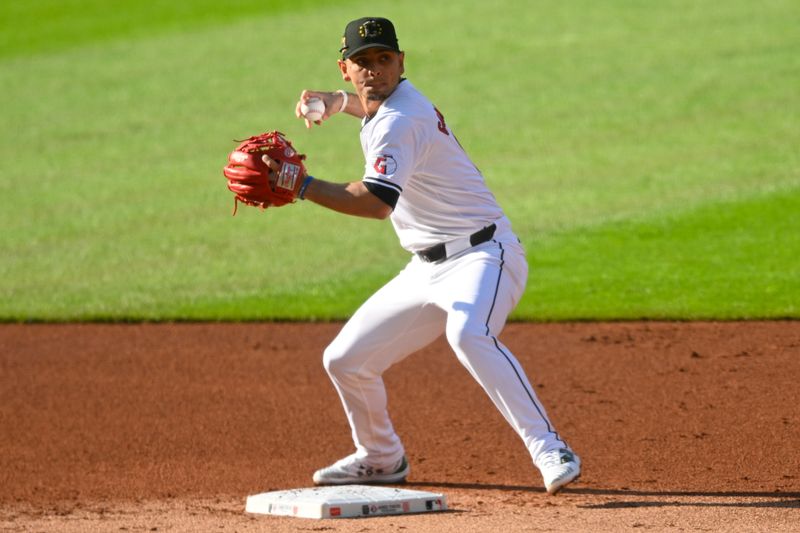 May 18, 2024; Cleveland, Ohio, USA; Cleveland Guardians second baseman Andres Gimenez (0) turns a double play in the first inning against the Minnesota Twins at Progressive Field. Mandatory Credit: David Richard-USA TODAY Sports