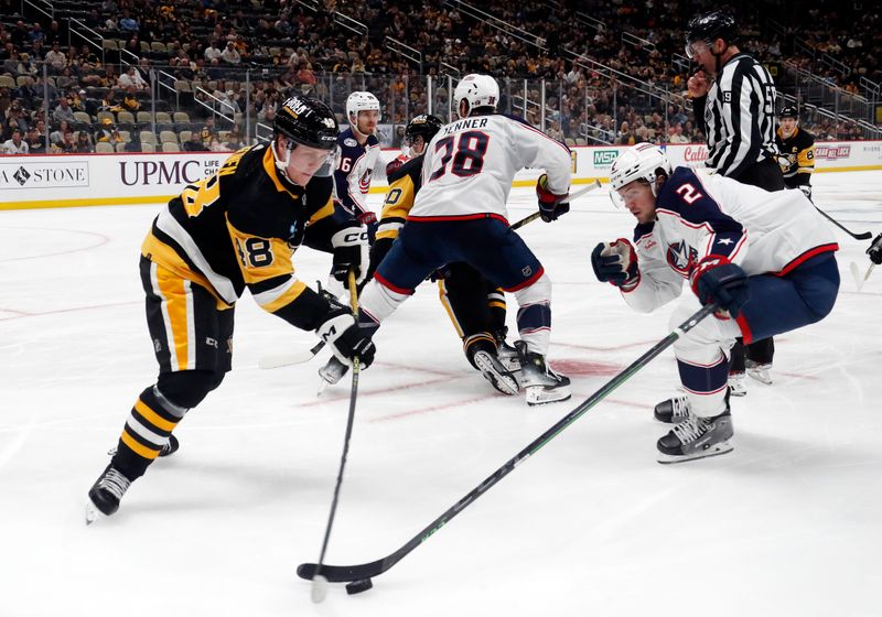 Mar 5, 2024; Pittsburgh, Pennsylvania, USA; Pittsburgh Penguins right wing Valtteri Puustinen (48) and Columbus Blue Jackets defenseman Andrew Peeke (2) reach for the puck during the third period at PPG Paints Arena. The Penguins won 5-3. Mandatory Credit: Charles LeClaire-USA TODAY Sports