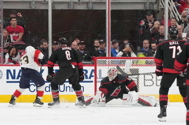 May 22, 2025; Raleigh, North Carolina, USA;   Carolina Hurricanes goaltender Pyotr Kochetkov (52) and defenseman Brent Burns (8) defend against Florida Panthers forward Brad Marchand (63) during the third period in game two of the Eastern Conference Final of the 2025 Stanley Cup Playoffs at Lenovo Center. Mandatory Credit: James Guillory-Imagn Images