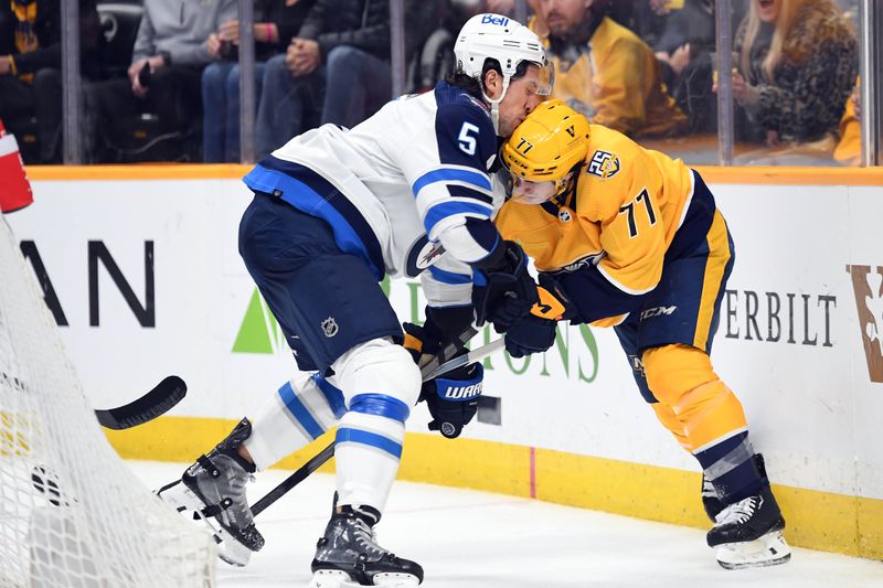 Apr 9, 2024; Nashville, Tennessee, USA; Nashville Predators right wing Luke Evangelista (77) is hit by Winnipeg Jets defenseman Brenden Dillon (5) during the third period at Bridgestone Arena. Mandatory Credit: Christopher Hanewinckel-USA TODAY Sports