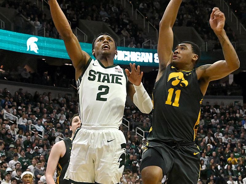 Feb 20, 2024; East Lansing, Michigan, USA;  Michigan State Spartans guard Tyson Walker (2) drives past Iowa Hawkeyes guard Tony Perkins (11) during the second half at Jack Breslin Student Events Center. Mandatory Credit: Dale Young-USA TODAY Sports
