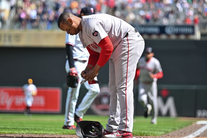 May 4, 2024; Minneapolis, Minnesota, USA; Boston Red Sox third base Rafael Devers (11) reacts after striking out with the bases loaded as Minnesota Twins pitcher Steven Okert (background) walks off the mound to end the seventh inning at Target Field. Mandatory Credit: Jeffrey Becker-USA TODAY Sports