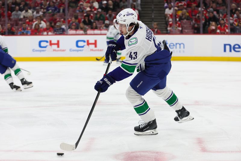 Oct 17, 2024; Sunrise, Florida, USA; Vancouver Canucks defenseman Quinn Hughes (43) moves the puck against the Florida Panthers during the first period at Amerant Bank Arena. Mandatory Credit: Sam Navarro-Imagn Images