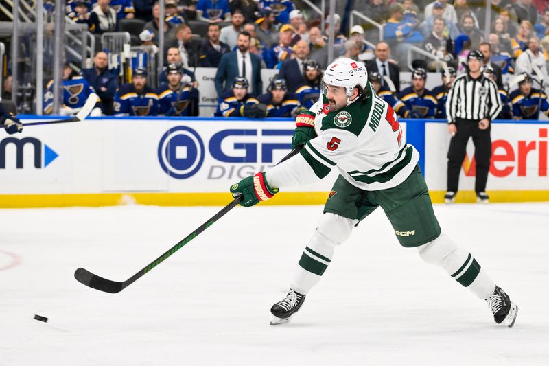 Nov 19, 2024; St. Louis, Missouri, USA;  Minnesota Wild defenseman Jake Middleton (5) shoots against the St. Louis Blues during the first period at Enterprise Center. Mandatory Credit: Jeff Curry-Imagn Images