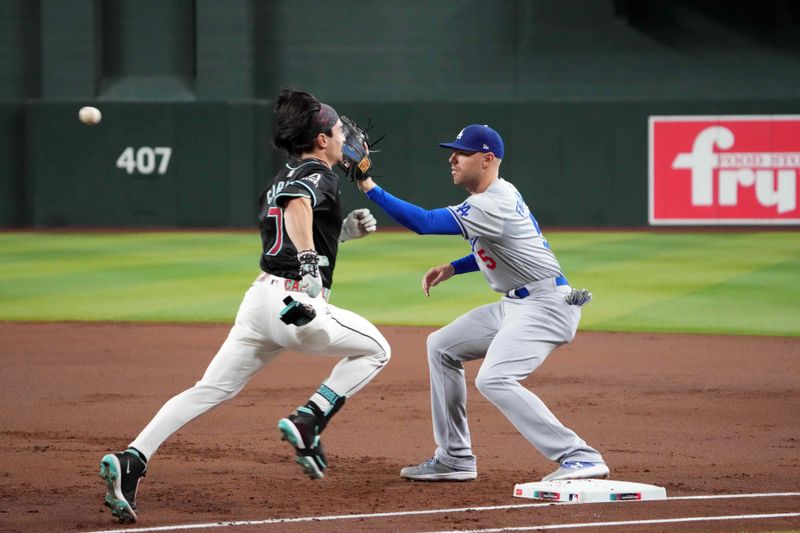 Sep 2, 2024; Phoenix, Arizona, USA; Los Angeles Dodgers first base Freddie Freeman (5) fields a throw to force out Arizona Diamondbacks outfielder Corbin Carroll (7) during the first inning at Chase Field. Mandatory Credit: Joe Camporeale-USA TODAY Sports