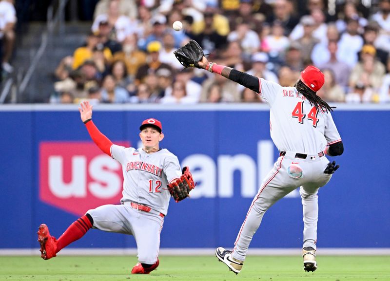 Sep 10, 2025; San Diego, California, USA; Cincinnati Reds left fielder Austin Hays (12) watches as shortstop Elly De La Cruz (44) makes a catch on a ball hit by San Diego Padres second baseman Jake Cronenworth (not pictured) looks on during the fourth inning at Petco Park. Mandatory Credit: Denis Poroy-Imagn Images