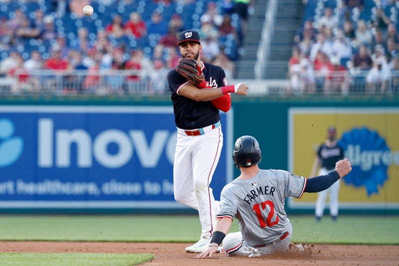 May 21, 2024; Washington, District of Columbia, USA; Washington Nationals second base Luis García Jr. (2) turns a double play ahead of a slide by Minnesota Twins third base Kyle Farmer (12) during the second inning at Nationals Park. Mandatory Credit: Geoff Burke-USA TODAY Sports