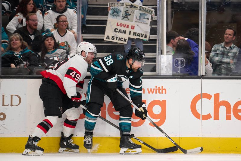 Mar 9, 2024; San Jose, California, USA: San Jose Sharks defenseman Mario Ferraro (38) controls the puck along the boards against Ottawa Senators center Rourke Chartier (49) during the first period at SAP Center at San Jose. Mandatory Credit: Robert Edwards-USA TODAY Sports