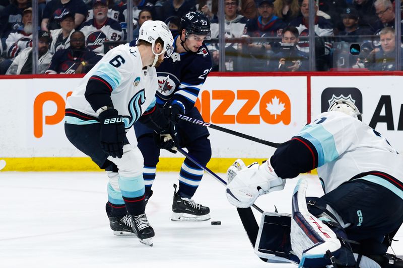 Apr 16, 2024; Winnipeg, Manitoba, CAN;  Winnipeg Jets forward Sean Monahan (23) battles Seattle Kraken defenseman Adam Larsson (6) for the puck during the second period at Canada Life Centre. Mandatory Credit: Terrence Lee-USA TODAY Sports