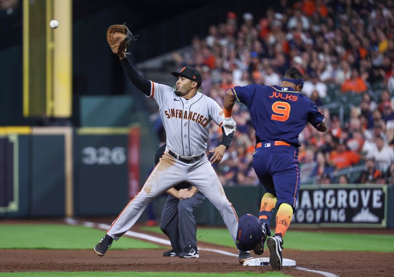 May 1, 2023; Houston, Texas, USA; Houston Astros left fielder Corey Julks (9) is out at first base as San Francisco Giants first baseman LaMonte Wade Jr. (31) fields a throw during the second inning at Minute Maid Park. Mandatory Credit: Troy Taormina-USA TODAY Sports