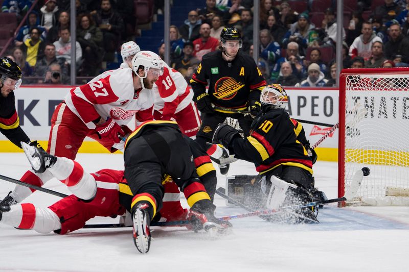 Feb 13, 2023; Vancouver, British Columbia, CAN; Vancouver Canucks forward J.T. Miller (9) and defenseman Quinn Hughes (43) and Detroit Red Wings forward Michael Rasmussen (27) look on as forward Robby Fabbri (14) scores on goalie Collin Delia (60) in the second period at Rogers Arena. Mandatory Credit: Bob Frid-USA TODAY Sports