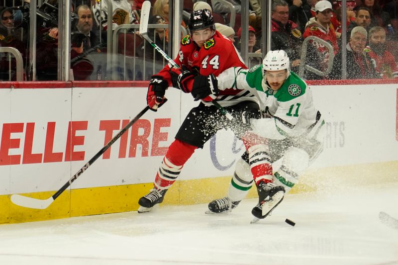 Nov 27, 2024; Chicago, Illinois, USA; Dallas Stars center Logan Stankoven (11) and Chicago Blackhawks defenseman Wyatt Kaiser (44) go for the puck during the second period at United Center. Mandatory Credit: David Banks-Imagn Images