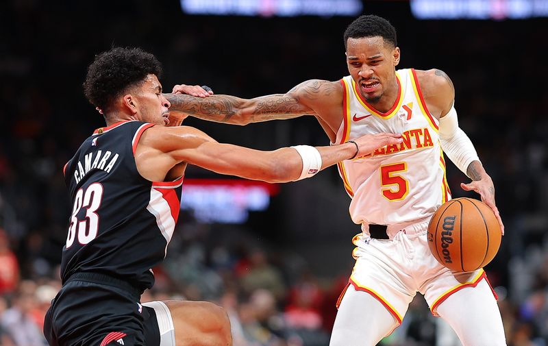 ATLANTA, GEORGIA - MARCH 27:  Dejounte Murray #5 of the Atlanta Hawks attempts a shot against Toumani Camara #33 of the Portland Trail Blazers during the fourth quarter at State Farm Arena on March 27, 2024 in Atlanta, Georgia.  NOTE TO USER: User expressly acknowledges and agrees that, by downloading and/or using this photograph, user is consenting to the terms and conditions of the Getty Images License Agreement.  (Photo by Kevin C. Cox/Getty Images)