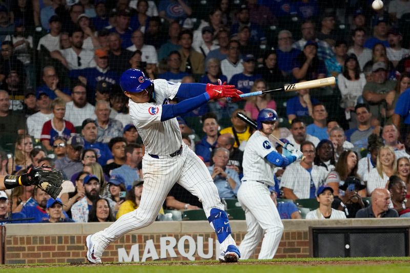 Sep 16, 2024; Chicago, Illinois, USA; Chicago Cubs catcher Miguel Amaya (9) hits a one run single against the Oakland Athletics during the second inning at Wrigley Field. Mandatory Credit: David Banks-Imagn Images