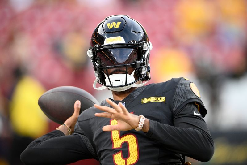 Washington Commanders quarterback Jayden Daniels warms up before a preseason NFL football game against the New England Patriots, Sunday, Aug. 25, 2024, in Landover, Md. (AP Photo/Nick Wass)