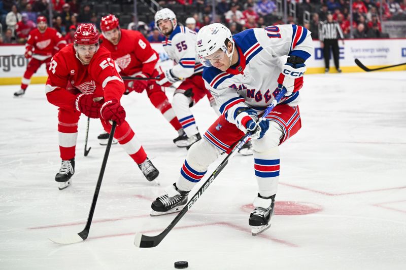 Apr 5, 2024; Detroit, Michigan, USA; New York Rangers left wing Artemi Panarin (10) brings the puck up ice against Detroit Red Wings defenseman Moritz Seider (53) during the first period at Little Caesars Arena. Mandatory Credit: Tim Fuller-USA TODAY Sports