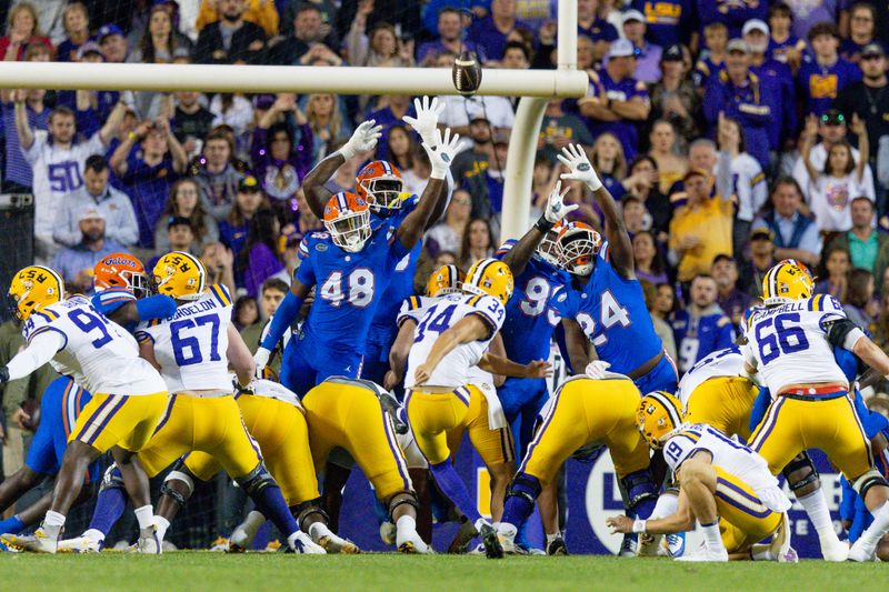 Nov 11, 2023; Baton Rouge, Louisiana, USA;  LSU Tigers place kicker Damian Ramos (34) kicks a field goal against Florida Gators defensive end Quincy Ivory (48) and defensive end Kamran James (24) during the first half at Tiger Stadium. Mandatory Credit: Stephen Lew-USA TODAY Sports