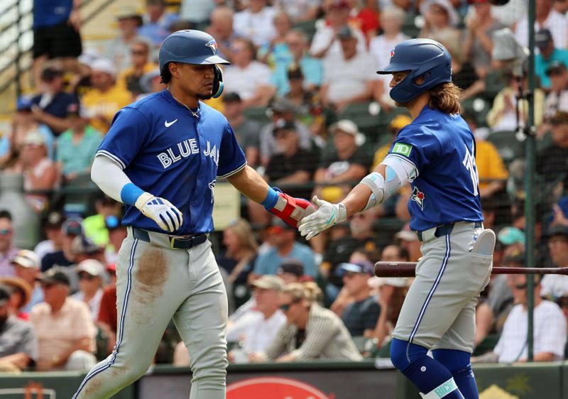 Mar 5, 2024; Bradenton, Florida, USA;  Toronto Blue Jays second baseman Santiago Espinal (5) is congratulated by shortstop Bo Bichette (11) after he scored a run during the third inning against the Pittsburgh Pirates at LECOM Park. Mandatory Credit: Kim Klement Neitzel-USA TODAY Sports