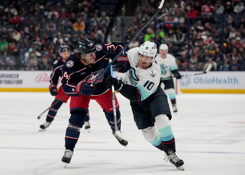 Mar 3, 2023; Columbus, Ohio, USA; Columbus Blue Jackets center Cole Sillinger (34) and Seattle Kraken center Matty Beniers (10) battle for position during the first period at Nationwide Arena. Mandatory Credit: Jason Mowry-USA TODAY Sports