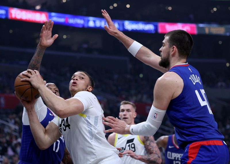 LOS ANGELES, CALIFORNIA - APRIL 12: Kenneth Lofton Jr. #34 of the Utah Jazz looks to pass between P.J. Tucker #17 and Ivica Zubac #40 of the LA Clippers during the first half at Crypto.com Arena on April 12, 2024 in Los Angeles, California. User is consenting to the terms and conditions of the Getty Images License Agreement.  (Photo by Harry How/Getty Images)