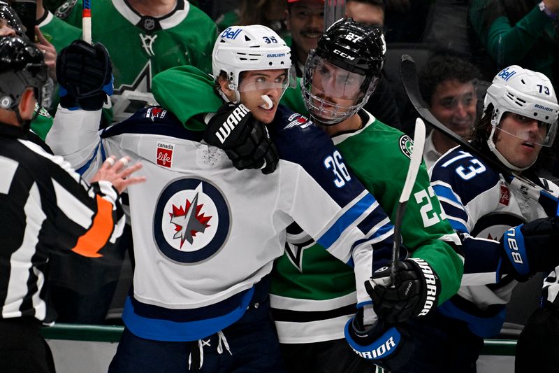 Apr 10, 2025; Dallas, Texas, USA; Dallas Stars left wing Mason Marchment (27) holds back Winnipeg Jets center Morgan Barron (36) during the first period at the American Airlines Center. Mandatory Credit: Jerome Miron-Imagn Images