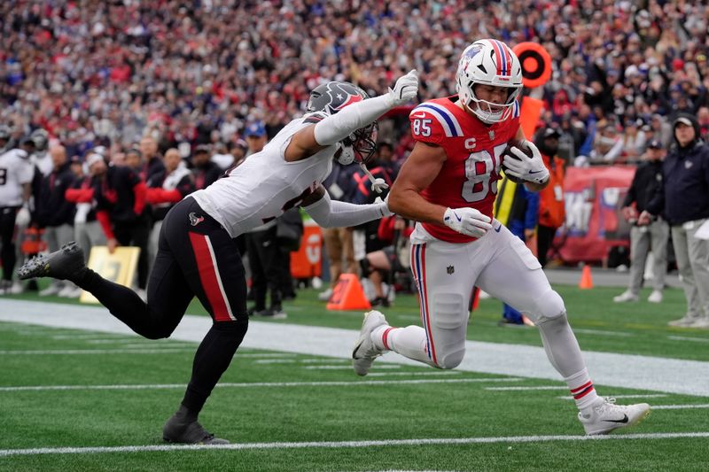 New England Patriots tight end Hunter Henry (85) scores against Houston Texans safety Jalen Pitre, left, during the second half of an NFL football game, Sunday, Oct. 13, 2024, in Foxborough, Mass. (AP Photo/Steven Senne)