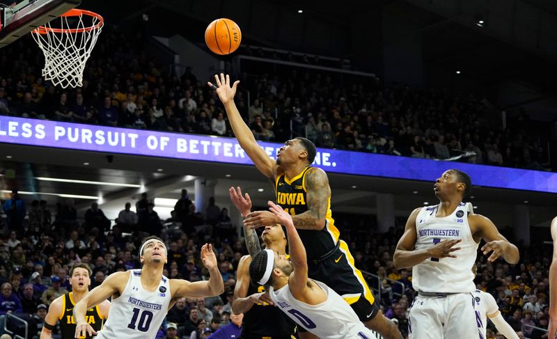 Feb 19, 2023; Evanston, Illinois, USA; Iowa Hawkeyes guard Tony Perkins (11) charges into Northwestern Wildcats guard Boo Buie (0) during the first half at Welsh-Ryan Arena. Mandatory Credit: David Banks-USA TODAY Sports