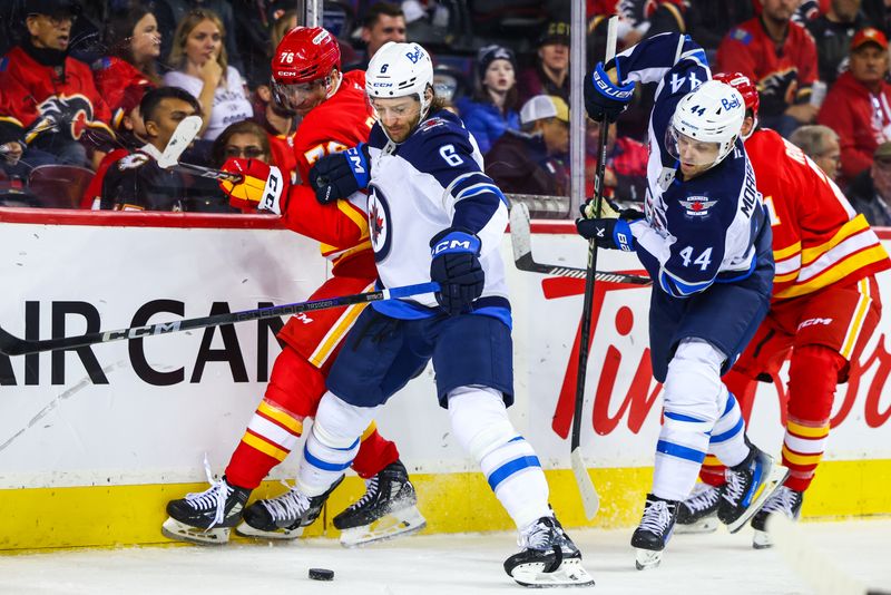 Oct 4, 2024; Calgary, Alberta, CAN; Winnipeg Jets defenseman Colin Miller (6) and Calgary Flames center Martin Pospisil (76) battles for the puck during the second period at Scotiabank Saddledome. Mandatory Credit: Sergei Belski-Imagn Images