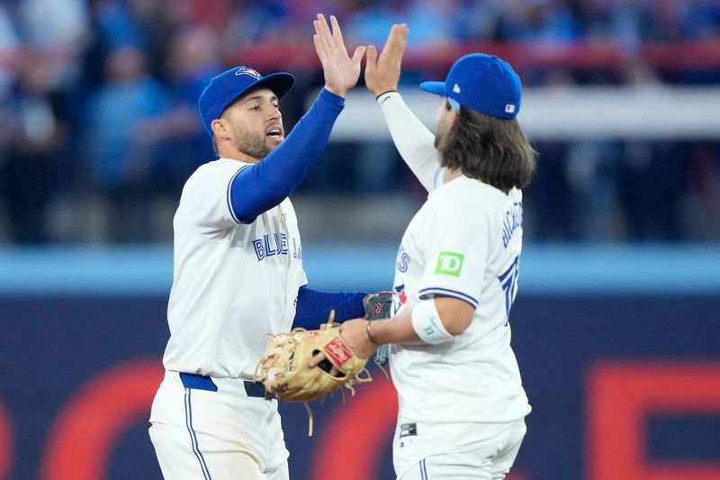 Apr 16, 2024; Toronto, Ontario, CAN; Toronto Blue Jays right fielder George Springer (left) and shortstop Bo Bichette (right) celebrate a win over the New York Yankees at Rogers Centre. Mandatory Credit: John E. Sokolowski-USA TODAY Sports