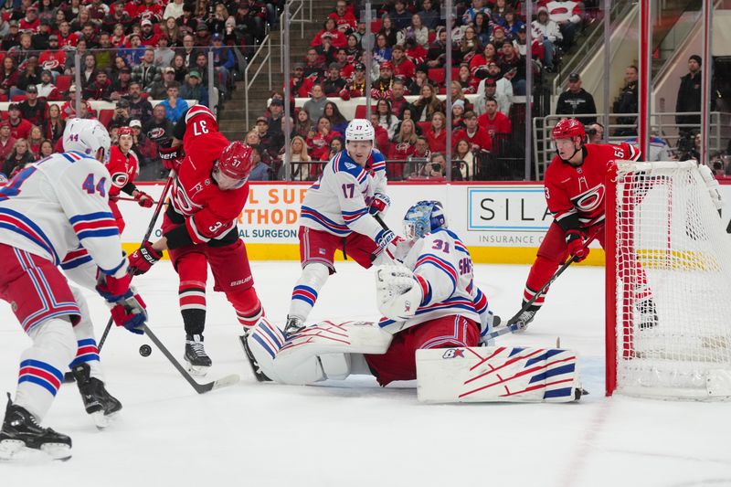 Dec 29, 2025; Raleigh, North Carolina, USA;  Carolina Hurricanes right wing Andrei Svechnikov (37) can’t get to the puck against New York Rangers goaltender Igor Shesterkin (31) and defenseman Will Borgen (17) during the first period at Lenovo Center. Mandatory Credit: James Guillory-Imagn Images