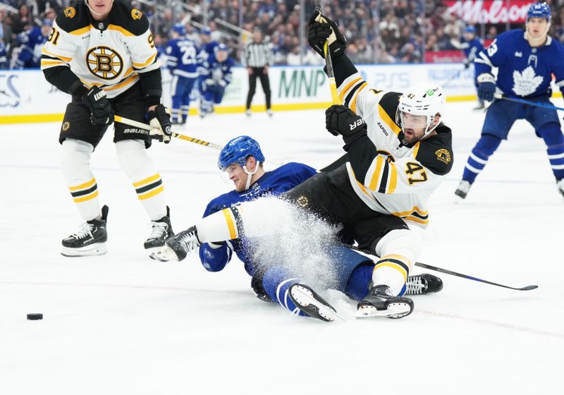 Nov 5, 2024; Toronto, Ontario, CAN; Toronto Maple Leafs center Steven Lorentz (18) battles for the puck with Boston Bruins center Mark Kastelic (47) during the third period at Scotiabank Arena. Mandatory Credit: Nick Turchiaro-Imagn Imagess