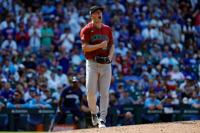 Jul 19, 2024; Chicago, Illinois, USA; Arizona Diamondbacks relief pitcher Paul Sewald (38) reacts after delivering a final out against the Chicago Cubs during the ninth inning at Wrigley Field. Mandatory Credit: Kamil Krzaczynski-USA TODAY Sports