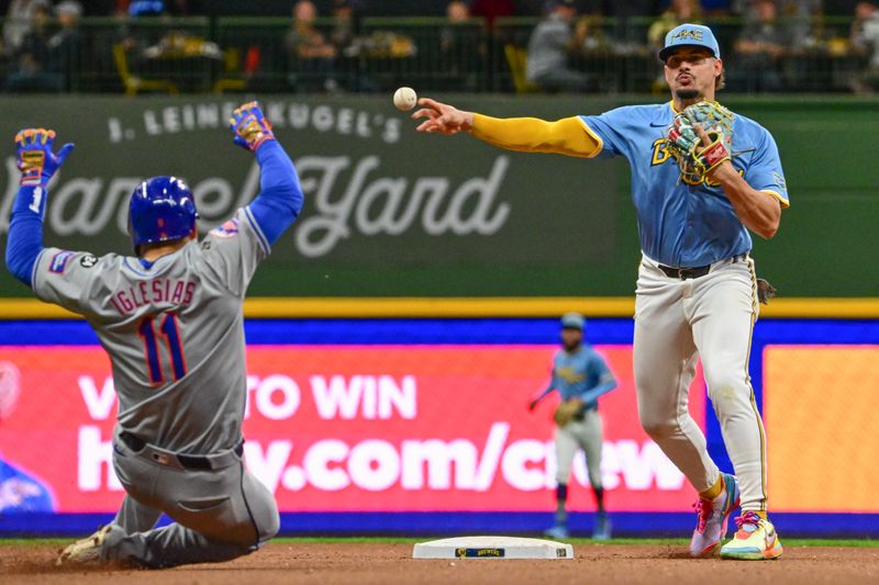 Sep 27, 2024; Milwaukee, Wisconsin, USA; Milwaukee Brewers shortstop Willy Adames (27) completes a double play after forcing out New York Mets second baseman Jose Iglesias (11) in the fifth inning at American Family Field. Mandatory Credit: Benny Sieu-Imagn Images