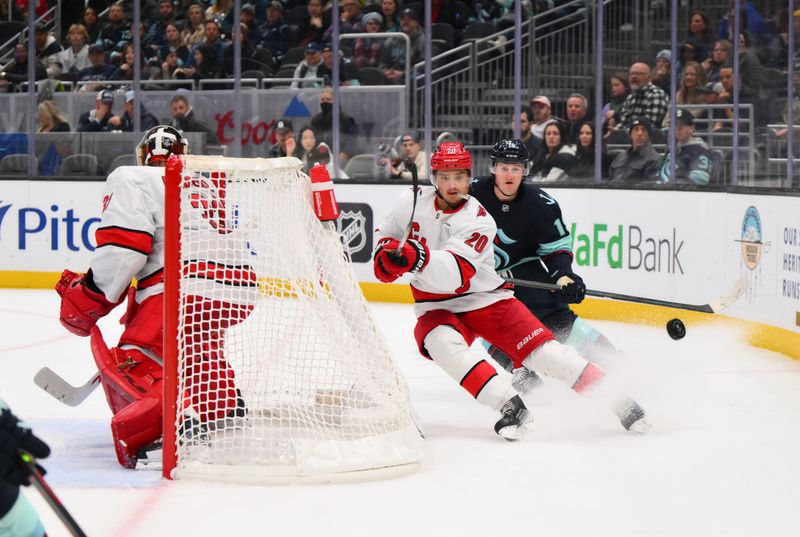 Oct 26, 2024; Seattle, Washington, USA; Carolina Hurricanes center Sebastian Aho (20) passes the puck away from Seattle Kraken left wing Jared McCann (19) during the third period at Climate Pledge Arena. Mandatory Credit: Steven Bisig-Imagn Images