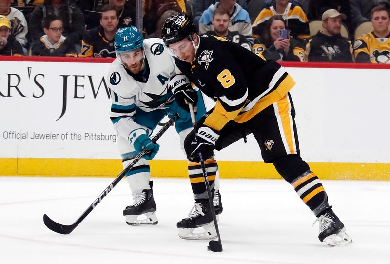 Mar 14, 2024; Pittsburgh, Pennsylvania, USA; Pittsburgh Penguins left wing Michael Bunting (8) moves the puck against San Jose Sharks center Luke Kunin (11) during the first period at PPG Paints Arena. Mandatory Credit: Charles LeClaire-USA TODAY Sports