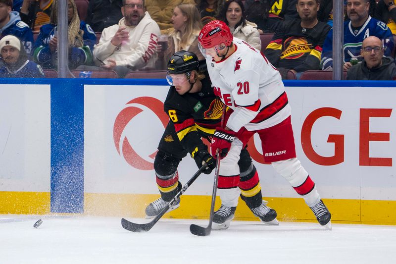 Oct 28, 2024; Vancouver, British Columbia, CAN; Carolina Hurricanes forward Sebastian Aho (20) checks Vancouver Canucks forward Brock Boeser (6) during the first period at Rogers Arena. Mandatory Credit: Bob Frid-Imagn Images