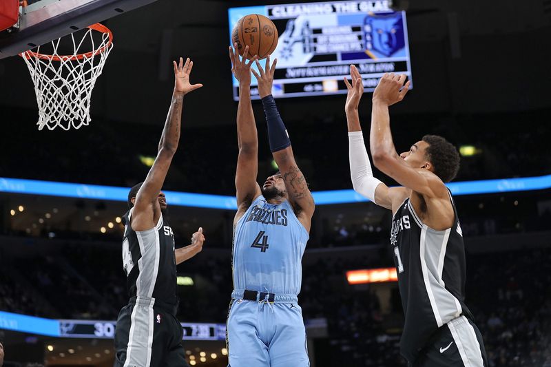 MEMPHIS, TENNESSEE - APRIL 09: Jordan Goodwin #4 of the Memphis Grizzlies puts up a shot against Victor Wembanyama #1 and Devonte' Graham #4 of the San Antonio Spurs during the first half at FedExForum on April 09, 2024 in Memphis, Tennessee. NOTE TO USER: User expressly acknowledges and agrees that, by downloading and or using this photograph, User is consenting to the terms and conditions of the Getty Images License Agreement. (Photo by Justin Ford/Getty Images)