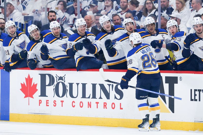 Apr 30, 2025; Winnipeg, Manitoba, CAN; St. Louis Blues forward Nathan Walker (26) is congratulated by his teammates on his goal against Winnipeg Jets goalie Connor Hellebuyck (37) during the first period in game five of the first round of the 2025 Stanley Cup Playoffs at Canada Life Centre. Mandatory Credit: Terrence Lee-Imagn Images