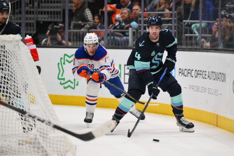 Mar 2, 2024; Seattle, Washington, USA; Seattle Kraken defenseman Justin Schultz (4) plays the puck while defended by Edmonton Oilers defenseman Vincent Desharnais (73) during the third period at Climate Pledge Arena. Mandatory Credit: Steven Bisig-USA TODAY Sports