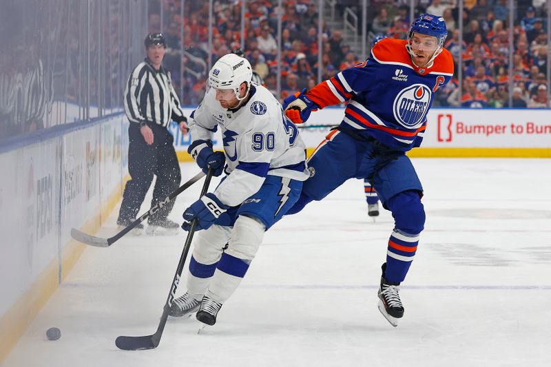 Mar 21, 2026; Edmonton, Alberta, CAN;  Edmonton Oilers forward Connor McDavid (97) jumps to avoid a hit from Tampa Bay Lightning defensemen J.J. Moser (90) during the first period at Rogers Place. Mandatory Credit: Perry Nelson-Imagn Images