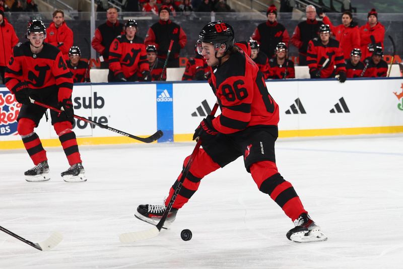 Feb 17, 2024; East Rutherford, New Jersey, USA; New Jersey Devils center Jack Hughes (86) skates with the puck against the Philadelphia Flyers during the second period in a Stadium Series ice hockey game at MetLife Stadium. Mandatory Credit: Ed Mulholland-USA TODAY Sports