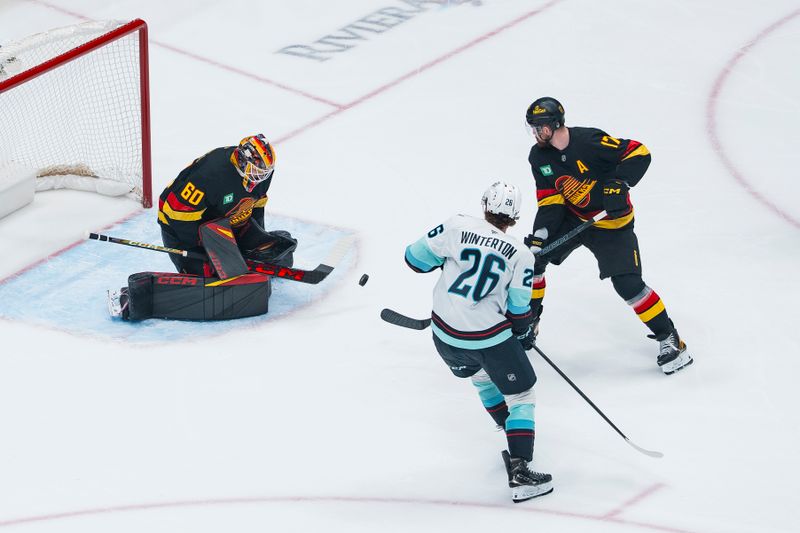 Mar 14, 2026; Vancouver, British Columbia, CAN; Seattle Kraken forward Ryan Winterton (26) and Vancouver Canucks defenseman Filip Hronek (17) watch as goalie Nikita Tolopilo (60) makes a save in the first period at Rogers Arena. Mandatory Credit: Bob Frid-Imagn Images