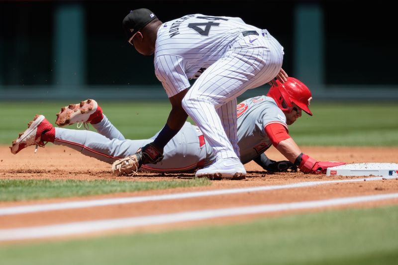 Jun 5, 2024; Denver, Colorado, USA; Cincinnati Reds outfielder TJ Friedl (29) dives safely into first against Colorado Rockies first base Elehuris Montero (44) during the first inning at Coors Field. Mandatory Credit: Andrew Wevers-USA TODAY Sports
