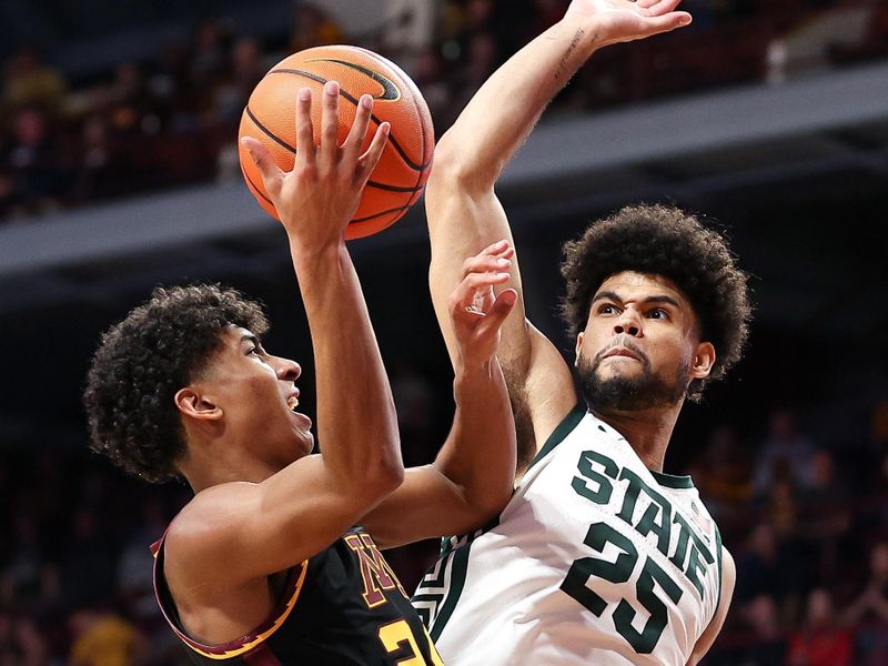 Feb 6, 2024; Minneapolis, Minnesota, USA; Minnesota Golden Gophers guard Cam Christie (24) shoots as Michigan State Spartans forward Malik Hall (25) defends during the first half at Williams Arena. Mandatory Credit: Matt Krohn-USA TODAY Sports