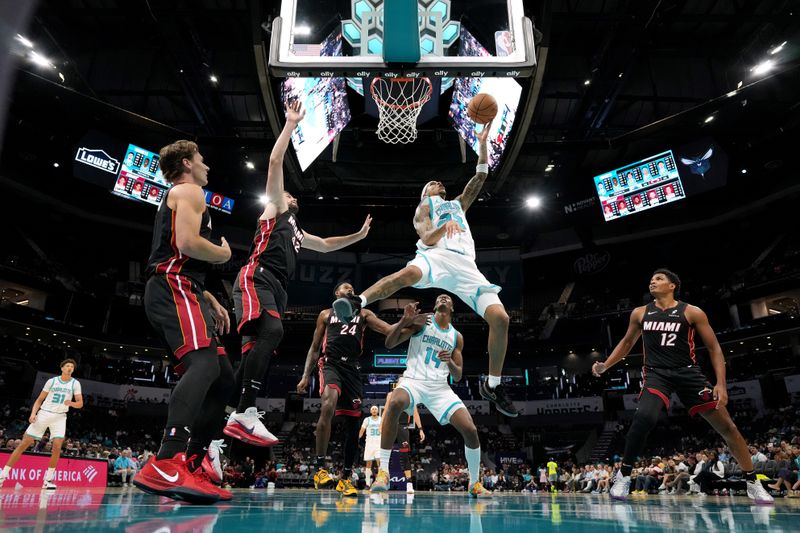 CHARLOTTE, NORTH CAROLINA - OCTOBER 08: Tre Mann #23 of the Charlotte Hornets goes to the basket against Kevin Love #42 of the Miami Heat during the first half of the preseason game at Spectrum Center on October 08, 2024 in Charlotte, North Carolina. NOTE TO USER: User expressly acknowledges and agrees that, by downloading and or using this photograph, User is consenting to the terms and conditions of the Getty Images License Agreement. (Photo by Grant Halverson/Getty Images)