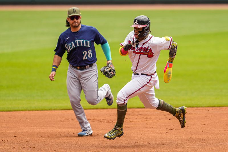 May 21, 2023; Cumberland, Georgia, USA; Atlanta Braves right fielder Ronald Acuna Jr. (13) runs past Seattle Mariners third baseman Eugenio Suarez (28) on his way to scoring a run during the first inning at Truist Park. Mandatory Credit: Dale Zanine-USA TODAY Sports