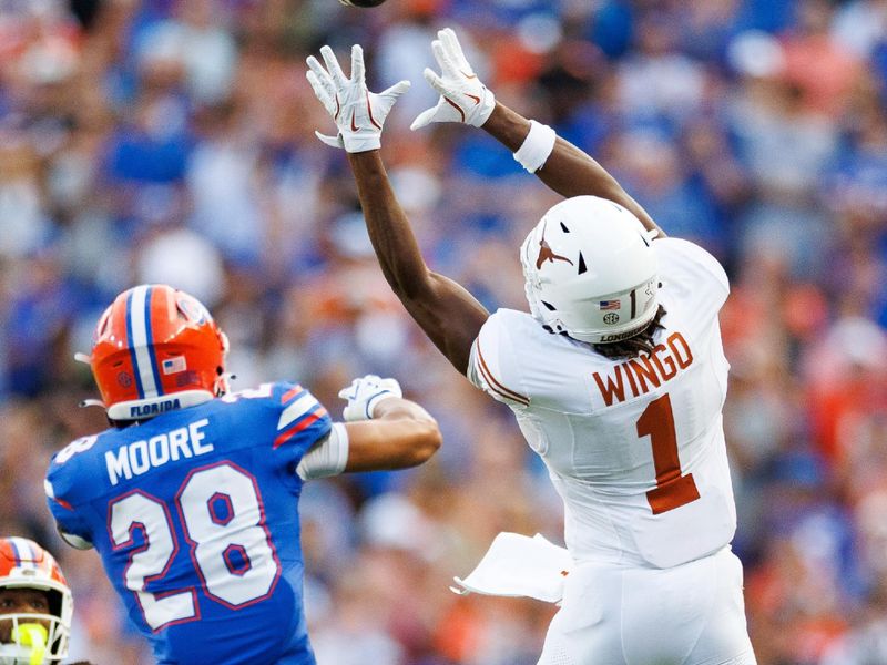 Oct 4, 2025; Gainesville, Florida, USA; Texas Longhorns wide receiver Ryan Wingo (1) attempts a catch over Florida Gators defensive back Devin Moore (28) during the second half at Ben Hill Griffin Stadium. Mandatory Credit: Matt Pendleton-Imagn Images