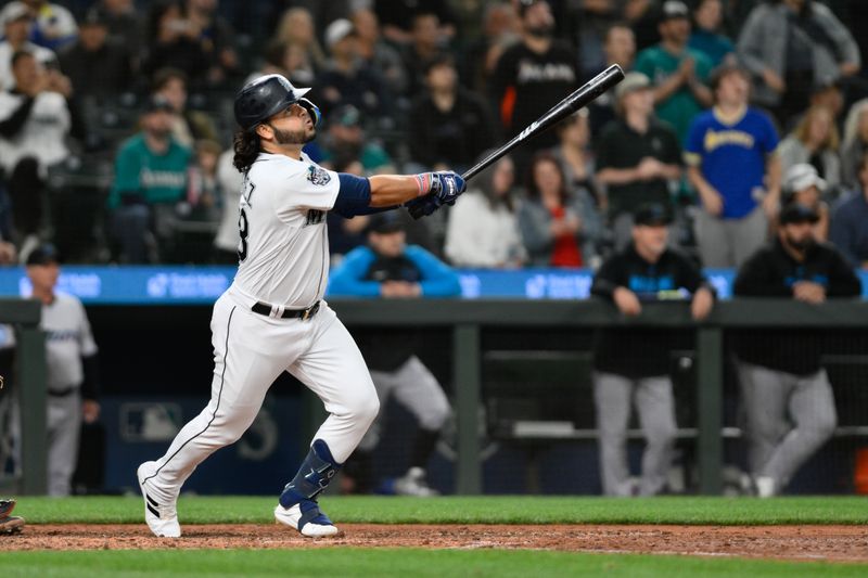 Jun 14, 2023; Seattle, Washington, USA; Seattle Mariners third baseman Eugenio Suarez (28) hits a sacrifice fly ball against the Miami Marlins during the ninth inning at T-Mobile Park. Mandatory Credit: Steven Bisig-USA TODAY Sports