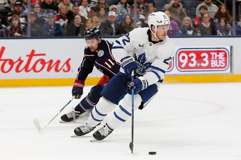 Oct 29, 2025; Columbus, Ohio, USA; Toronto Maple Leafs defenseman Jake McCabe (22) skates with the puck as Columbus Blue Jackets left wing Miles Wood (11) trails the play during the second period at Nationwide Arena. Mandatory Credit: Russell LaBounty-Imagn Images