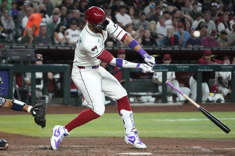 Apr 27, 2025; Phoenix, Arizona, USA; Arizona Diamondbacks outfielder Lourdes Gurriel Jr. (12) loses his bat against the Atlanta Braves in the fourth inning at Chase Field. Mandatory Credit: Rick Scuteri-Imagn Images